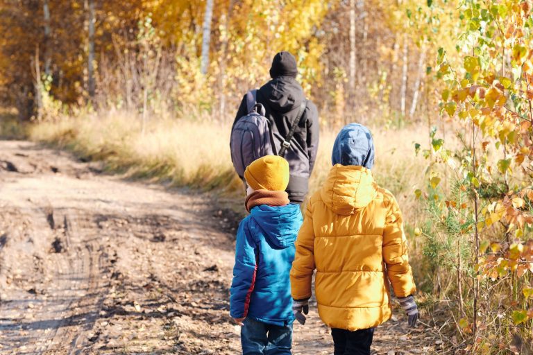 walk through the autumn forest of dad and children. Refugees cross the border